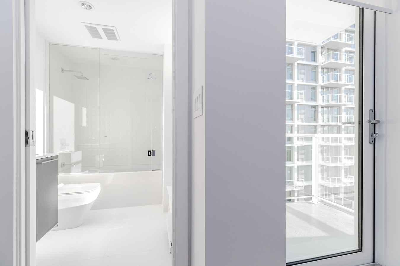 partial view into bathroom with toilet and bath tub