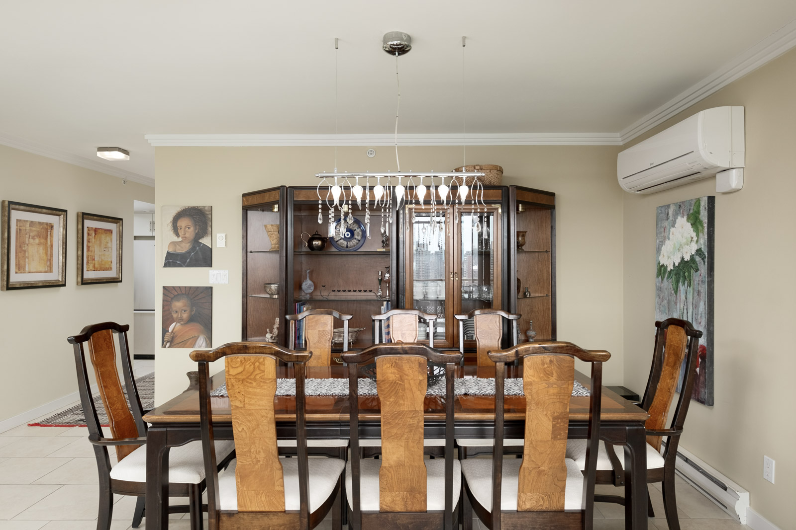 Dining area of furnished Vancouver rental condo with decorative shelving and hanging artwork.