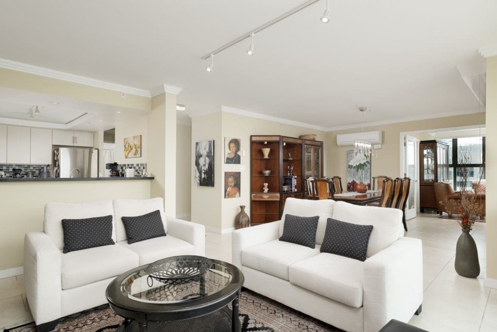 Living area of Vancouver rental with white couches and access to private balcony.
