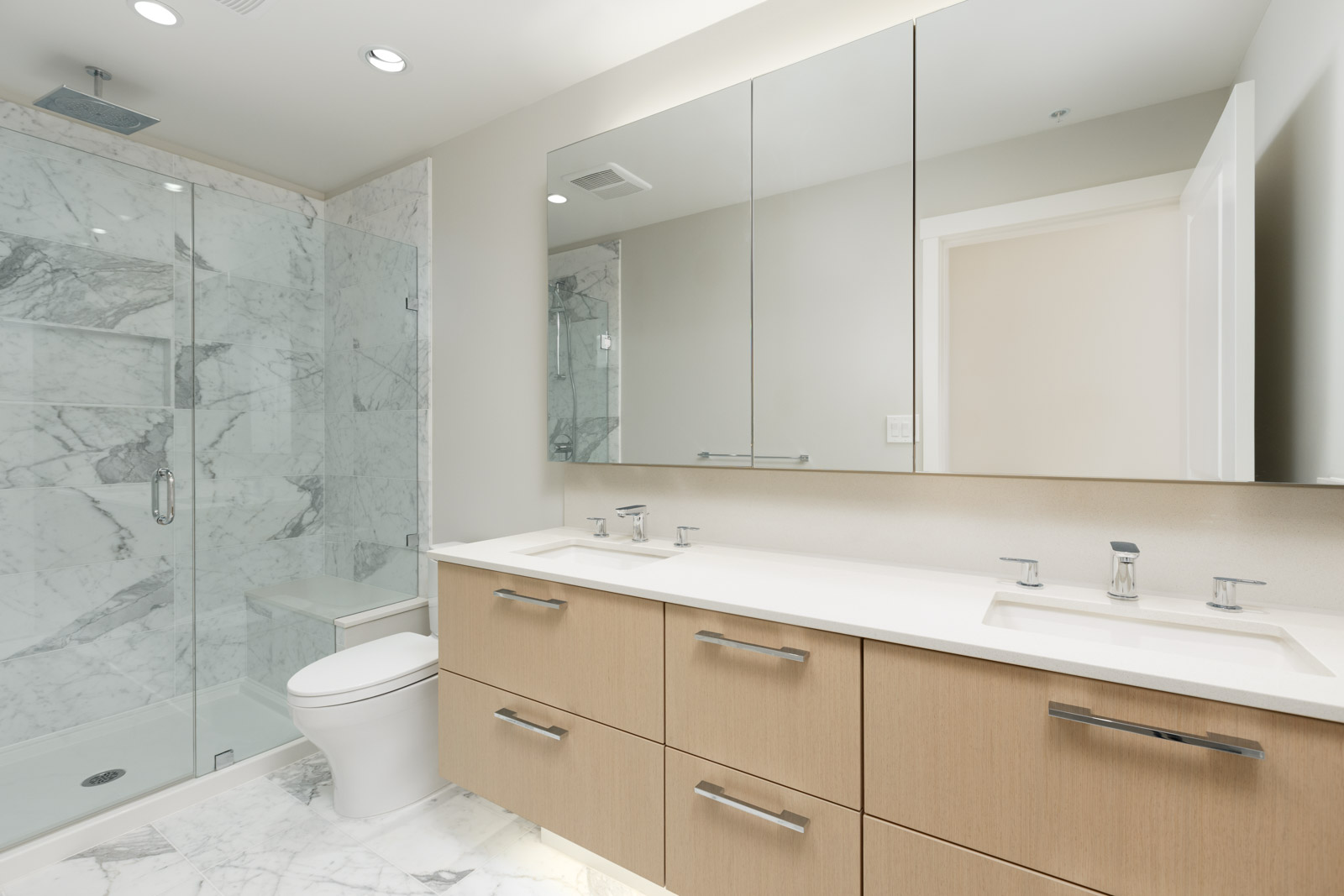Bathroom with mirrored cabinets inside newly built UBC luxury condo.