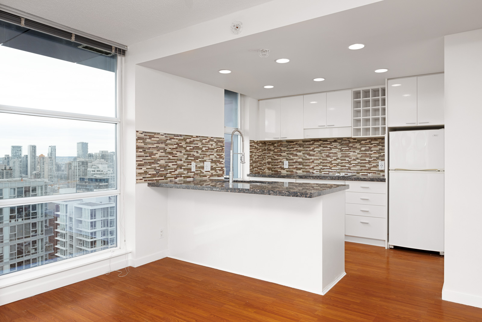 Kitchen with white cabinetry inside Downtown Vancouver rental condo.