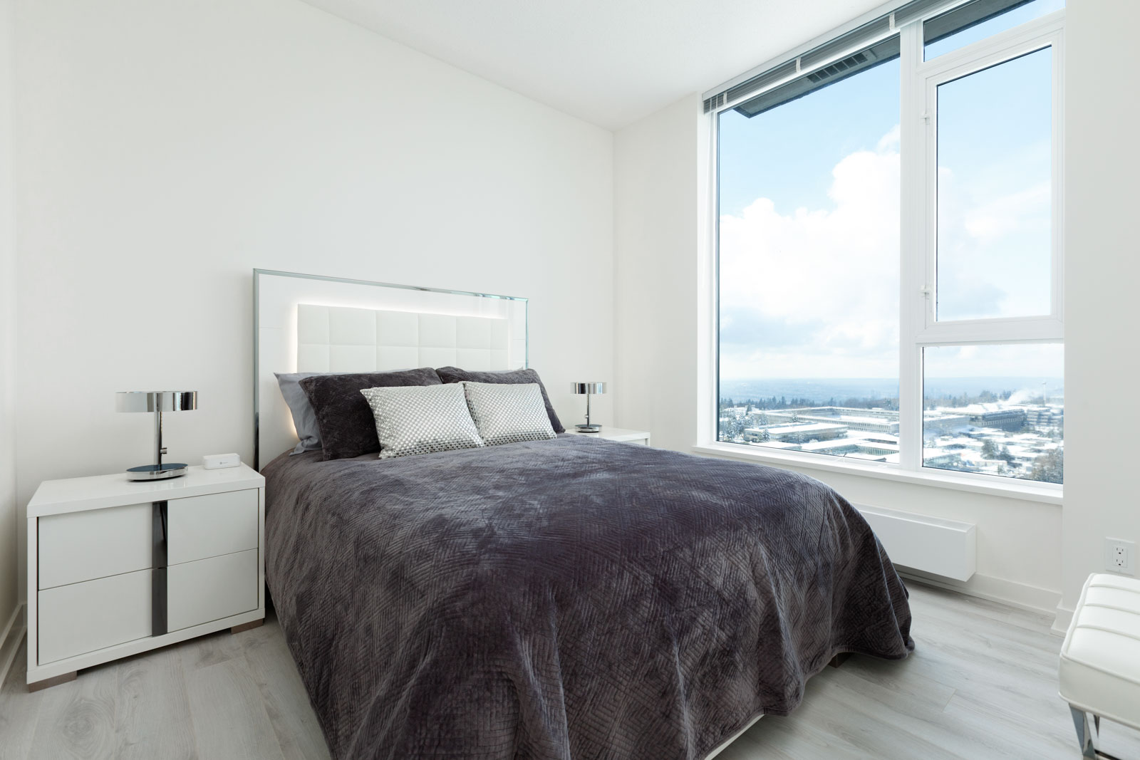 Bedroom inside luxury rental penthouse with views of Burnaby waterfront.