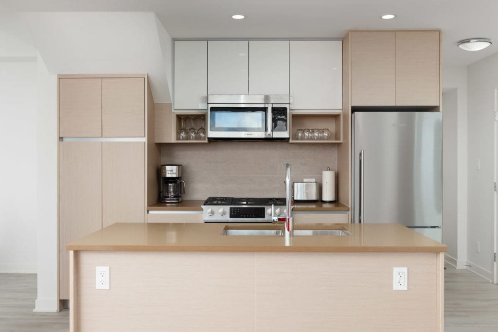 Kitchen with stainless steel appliances inside luxury Burnaby Mountain rental penthouse.