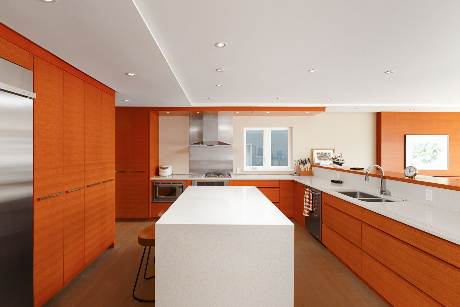 Kitchen with cherry wood cabinetry and a white island inside North Vancouver luxury rental.