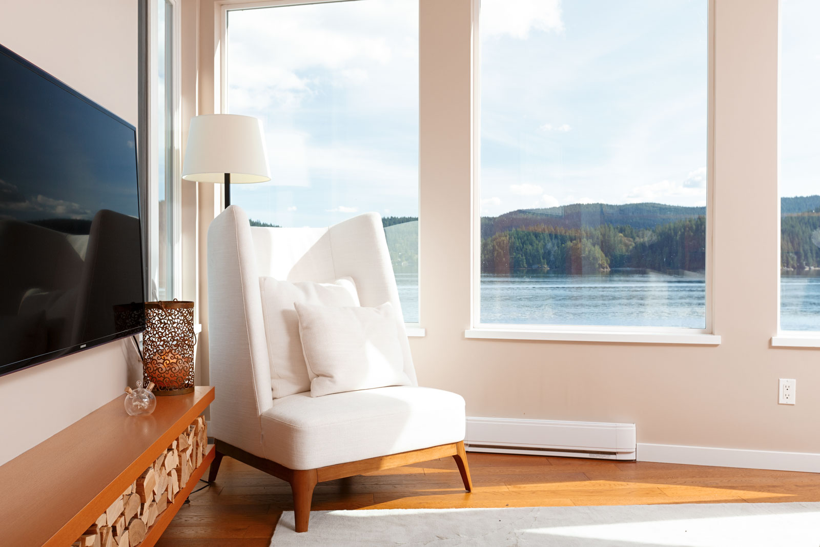 White chaise overlooking waterfront views from North Vancouver luxury rental.