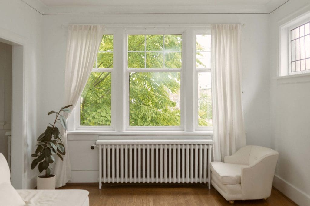 Living room in minimalist home with long white curtains