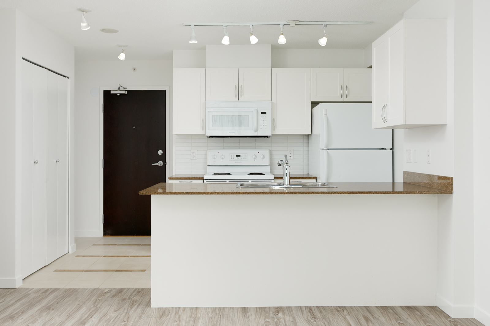 Kitchen with white cabinetry inside Vancouver rental condo.