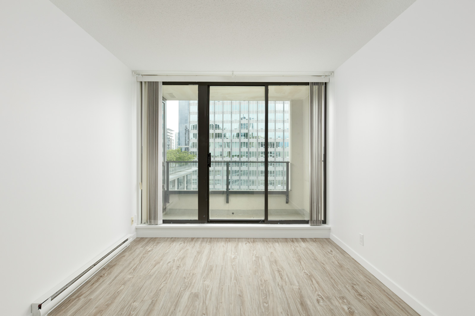 Bedroom with sliding door leading out to balcony of Downtown Vancouver rental condo.