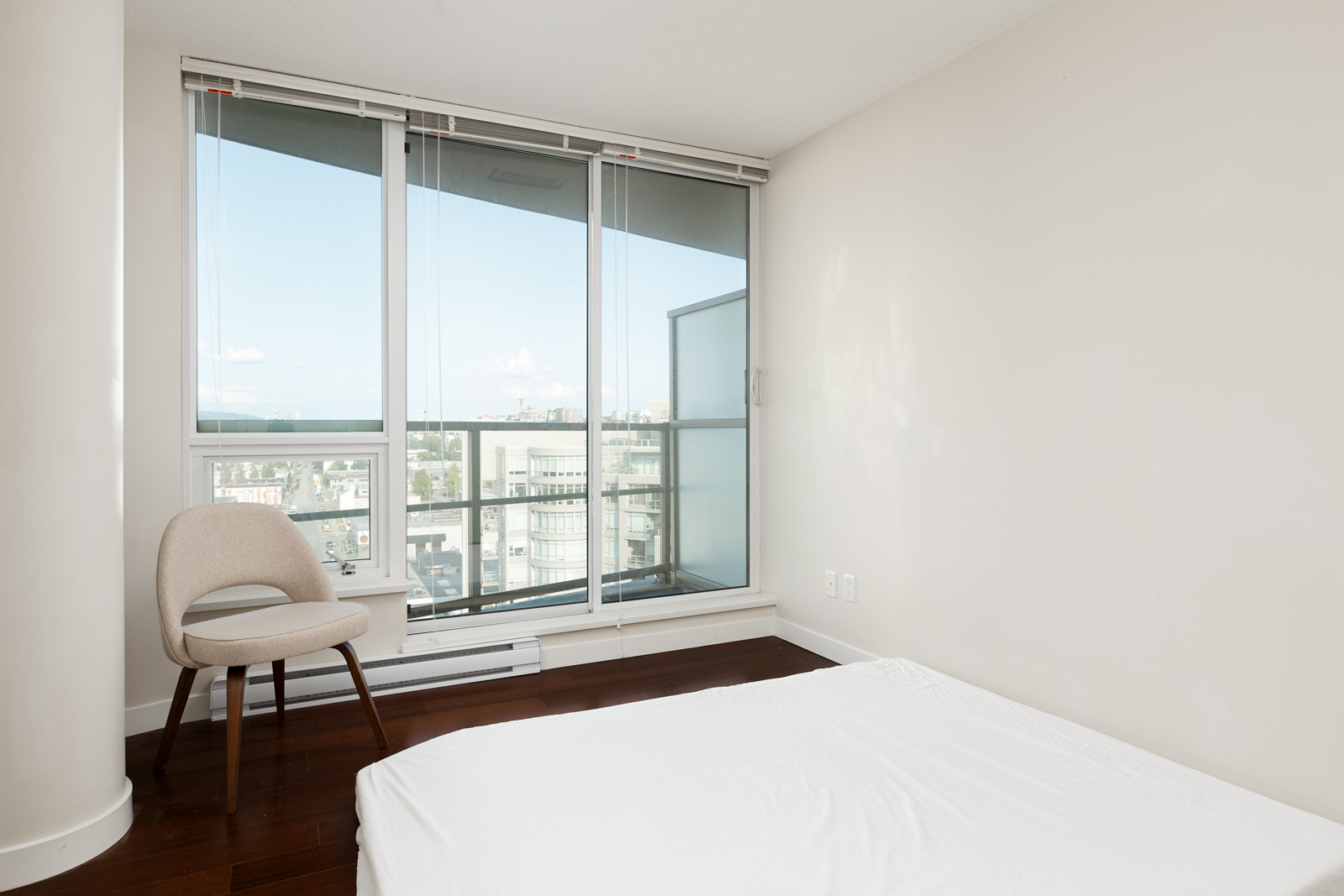 Bedroom opening up onto balcony of Vancouver high rise rental condo.