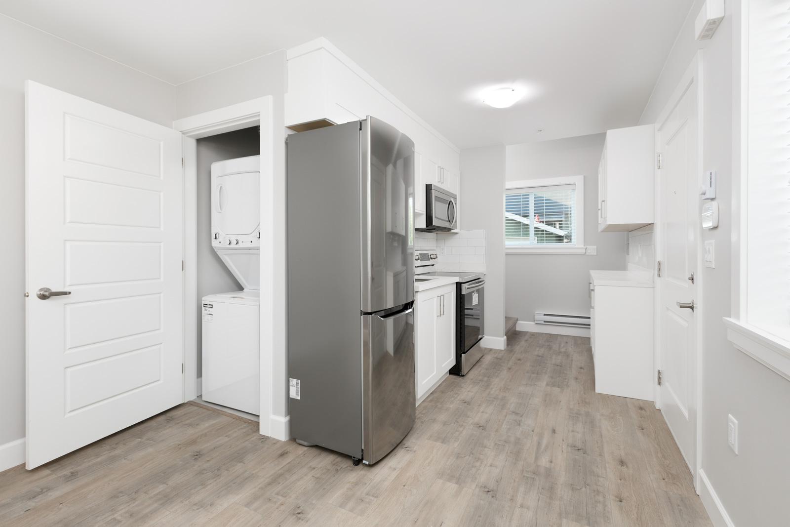 View of washer and dryer closet next to kitchen in Vancouver rental with stainless steel appliances in Vancouver unfurnished rental home..