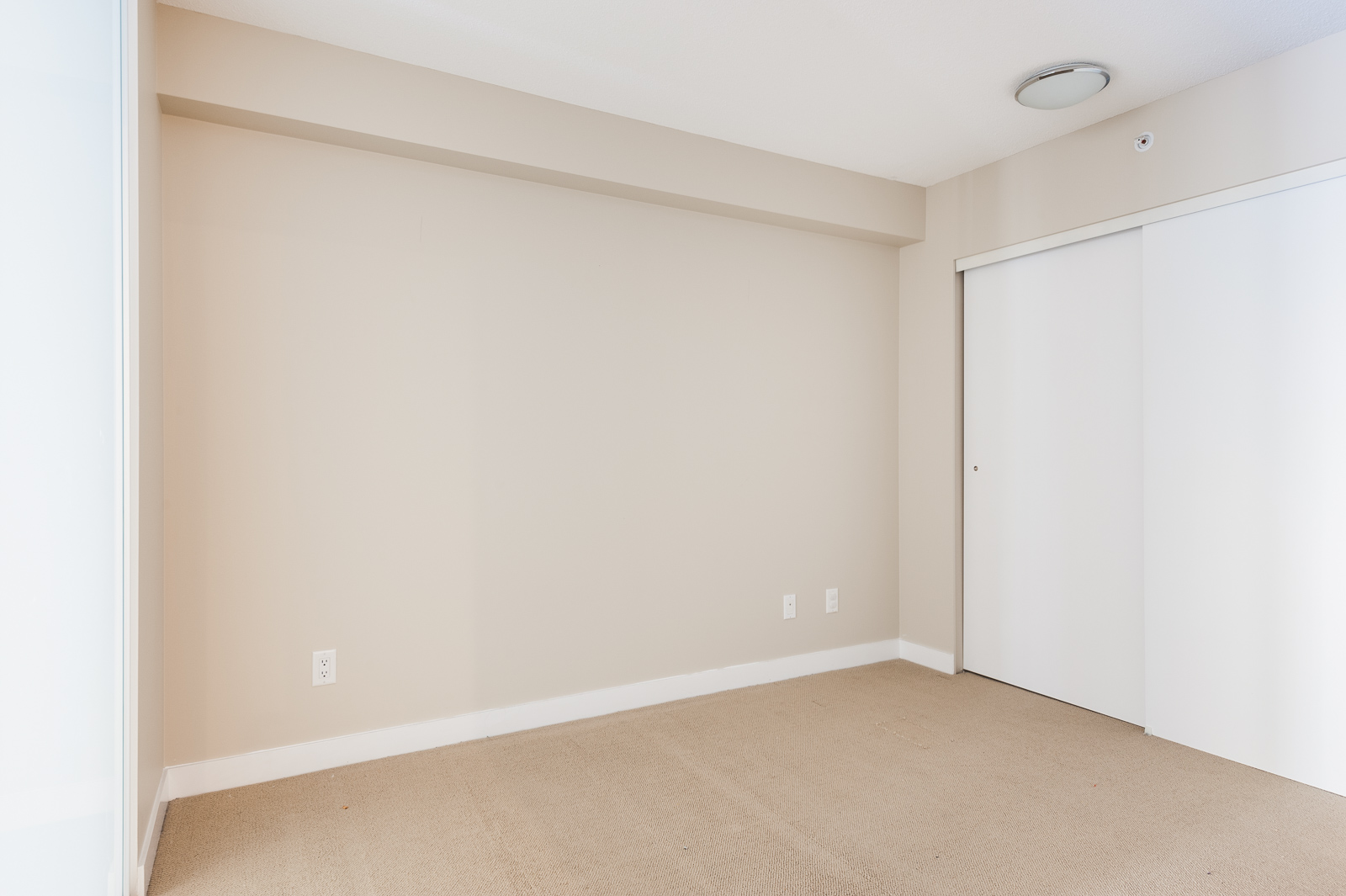 Carpeted bedroom in Chinatown Vancouver luxury rental.