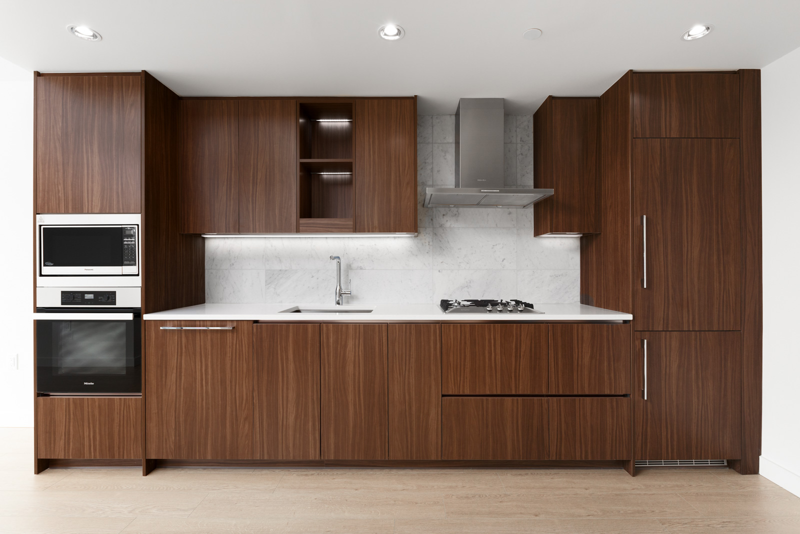 kitchen with dark wood cabinets along the wall of rental condo at arc vancouver building