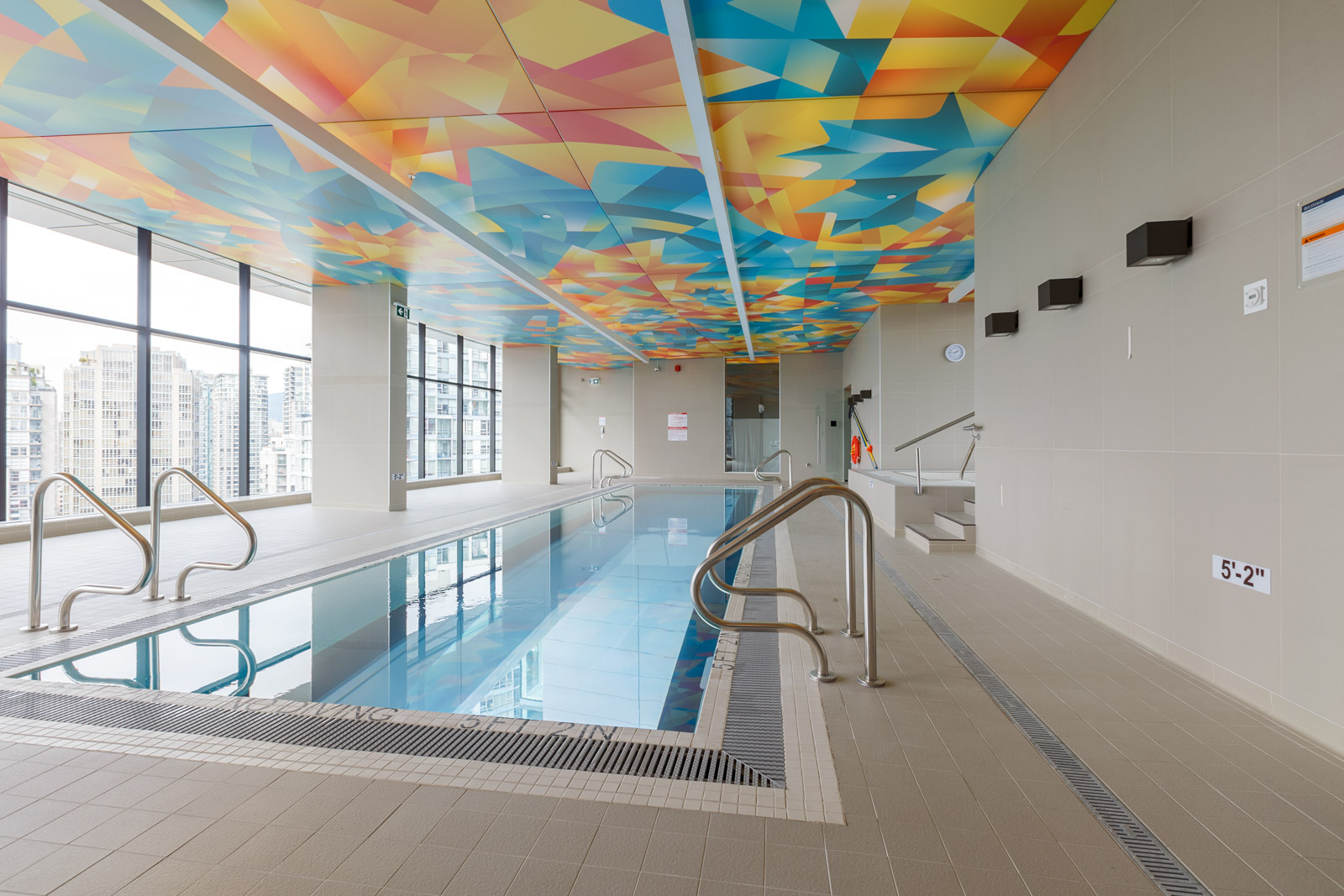indoor pool in the arc condo building in vancouver with colourful ceiling
