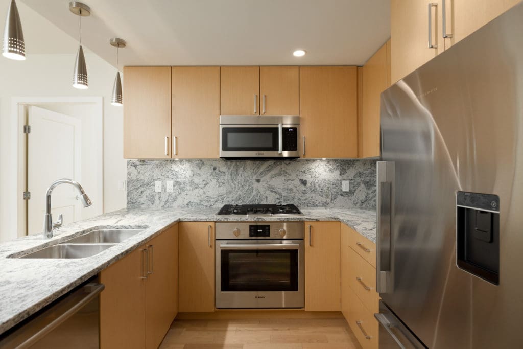 open kitchen in rental condo with wood cabinets stove oven microwave