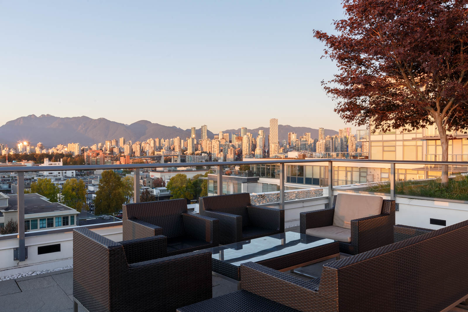 View of Burrard inlet and rooftop patio tables and chairs from Kits360 condo building in Kitsilano and Fairview