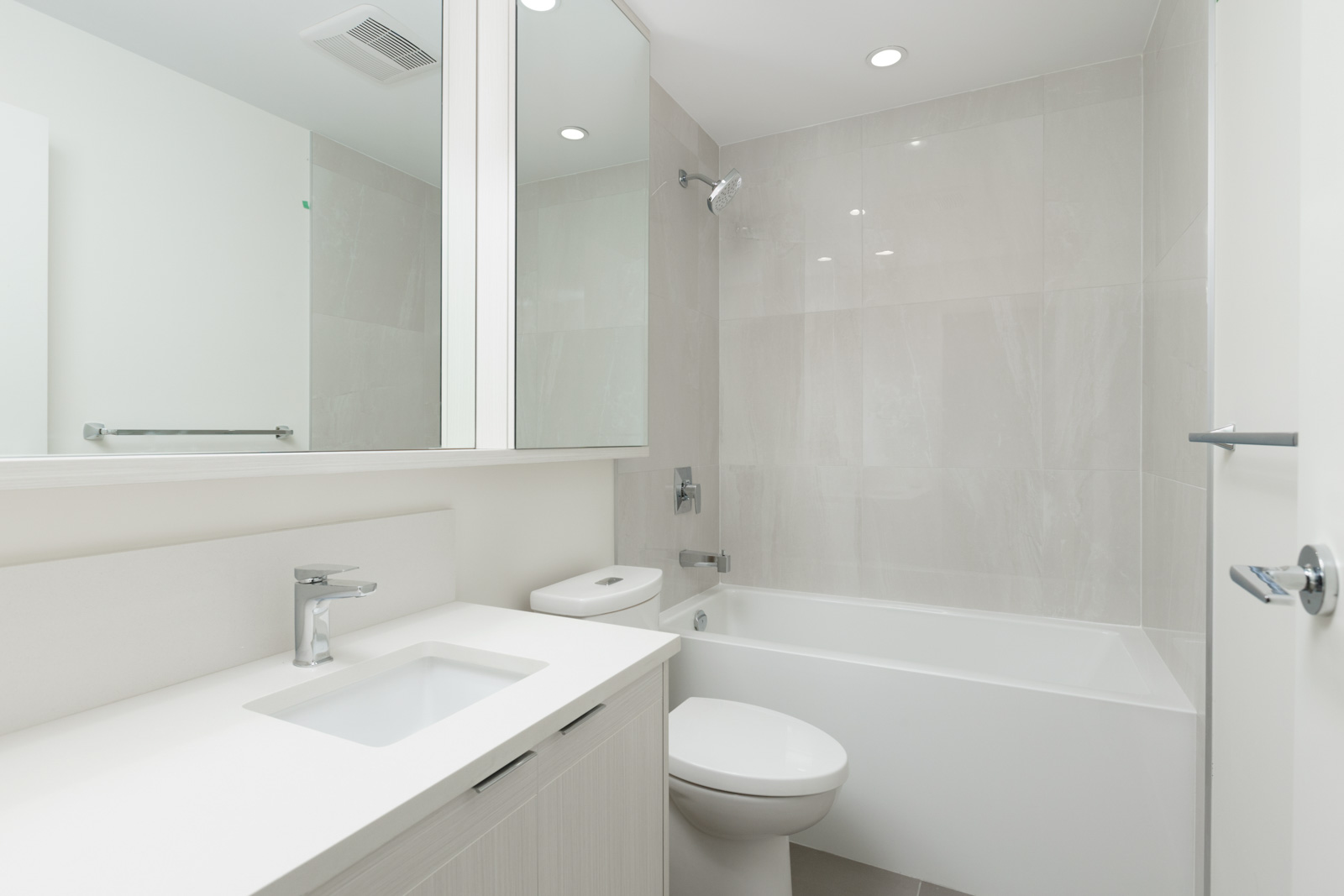 bathroom with mirror and white countertop and toilet and bathtub