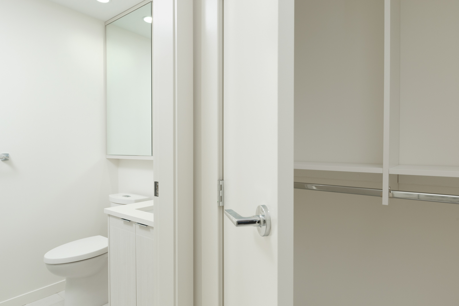 closets and bathroom with white doors and silver chrome handles in burnaby condo