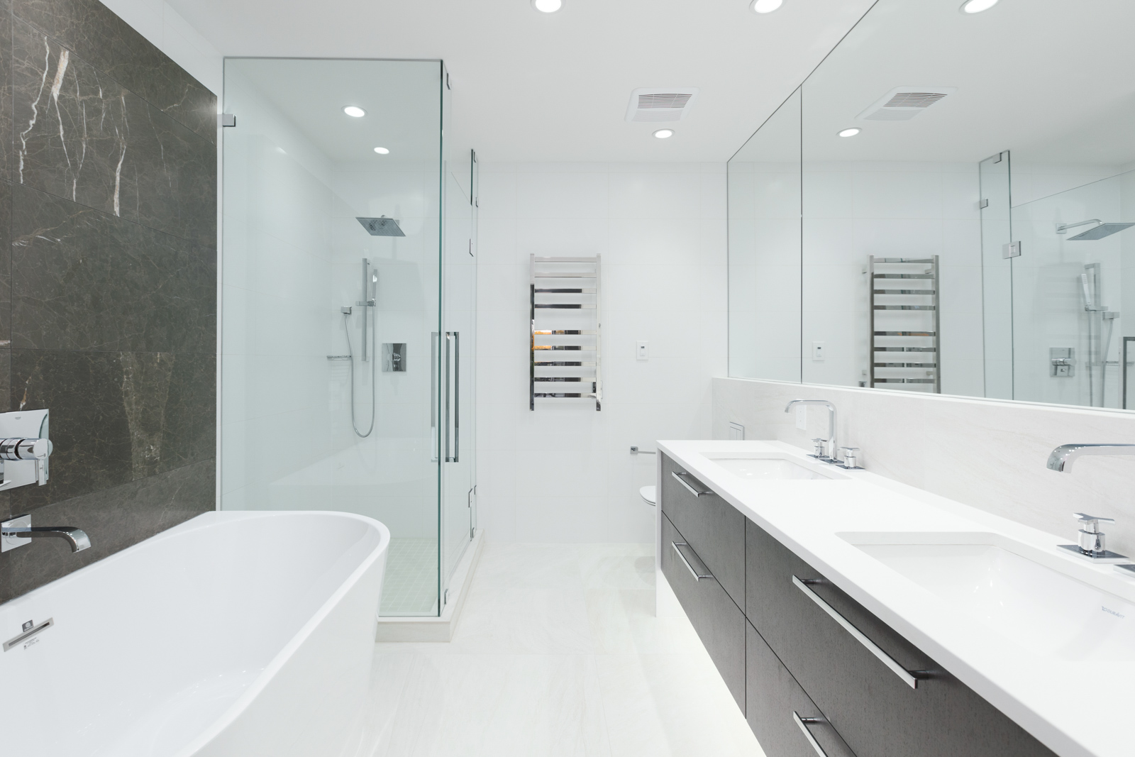 Bathroom with white floors and counters and glass door shower in rental property in The Kirkland building in Kerrisdale Vancouver
