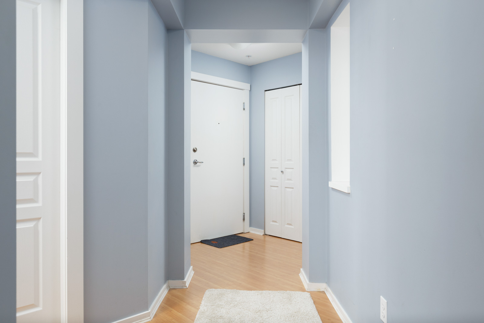 hallway with door and blue walls in burnaby condo for rent
