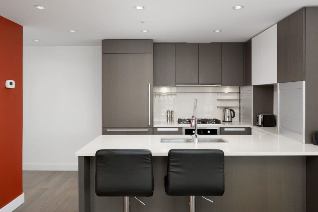 kitchen with counter and two stools with backs in false creek condo managed by birds nest properties