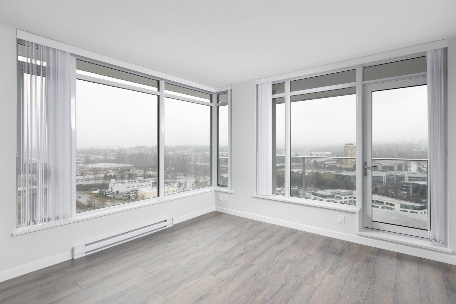 diagonal view of living room with windows in empty new rental condo at fulton house on madison in brentwood neighbourhood of burnaby