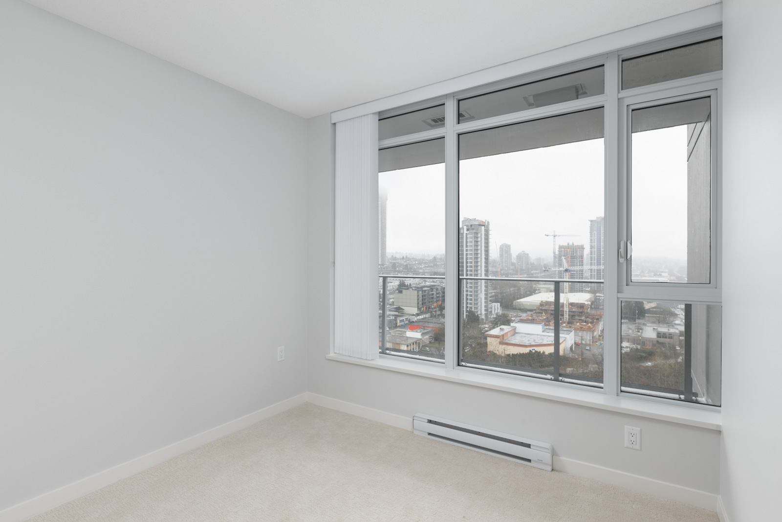 diagonal view in bedroom with windows on right in empty new rental condo at fulton house on madison in brentwood neighbourhood of burnaby
