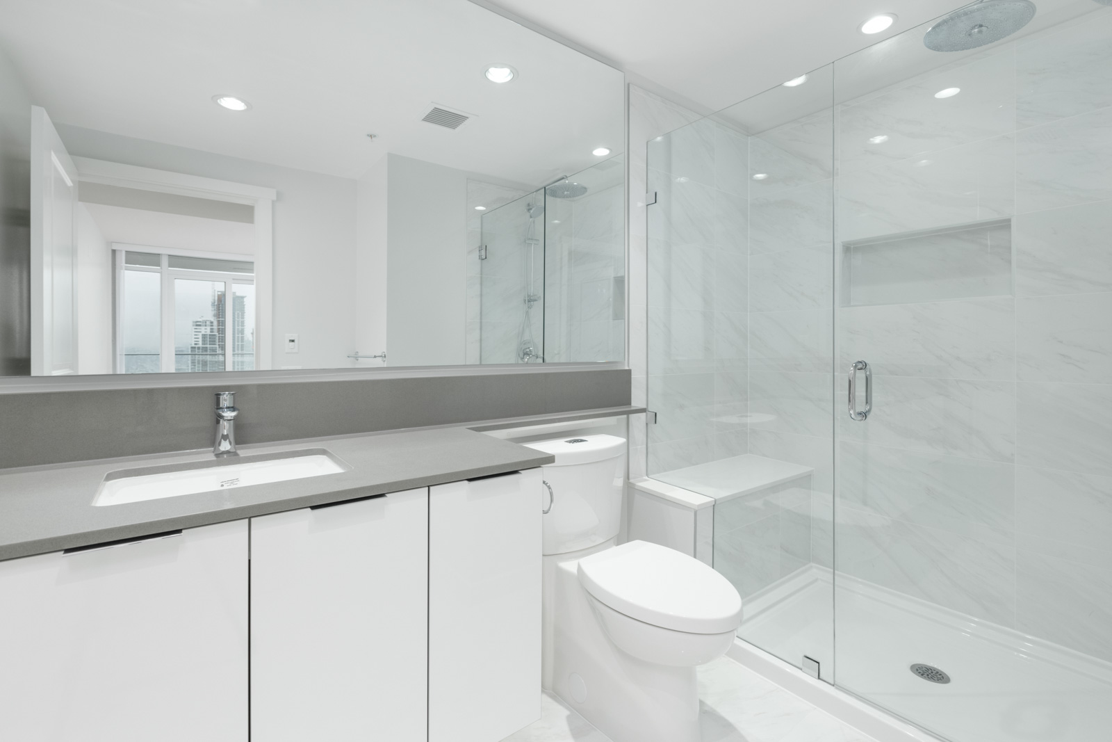bathroom with counter on left and toilet in centre and shower on right in empty new rental condo at fulton house on madison in brentwood neighbourhood of burnaby