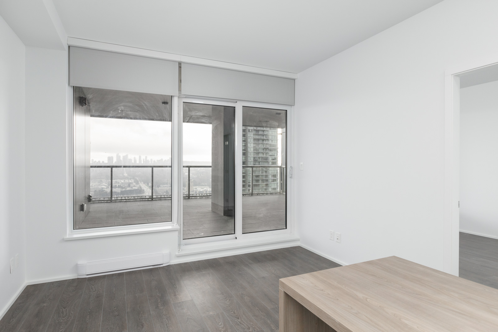 diagonal view of living room looking out windows in brand new condo at brentwood tower one of amazing brentwood in burnaby