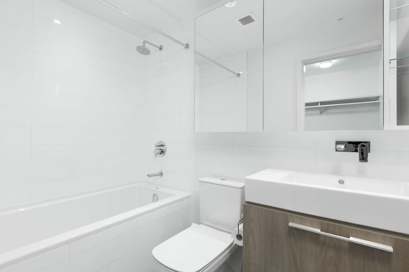 bathroom with toilet in middle and vanity on right and shower and tub on left in brand new condo at brentwood tower one in burnaby