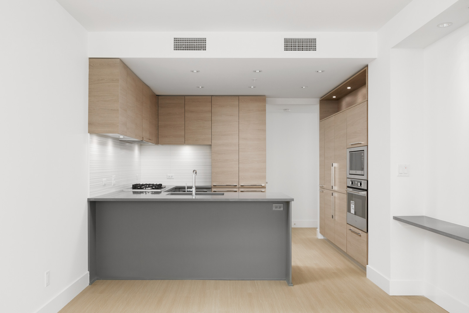 kitchen with counter and cabinets in empty brand new condo managed by birds nest properties at kings crossing in burnaby