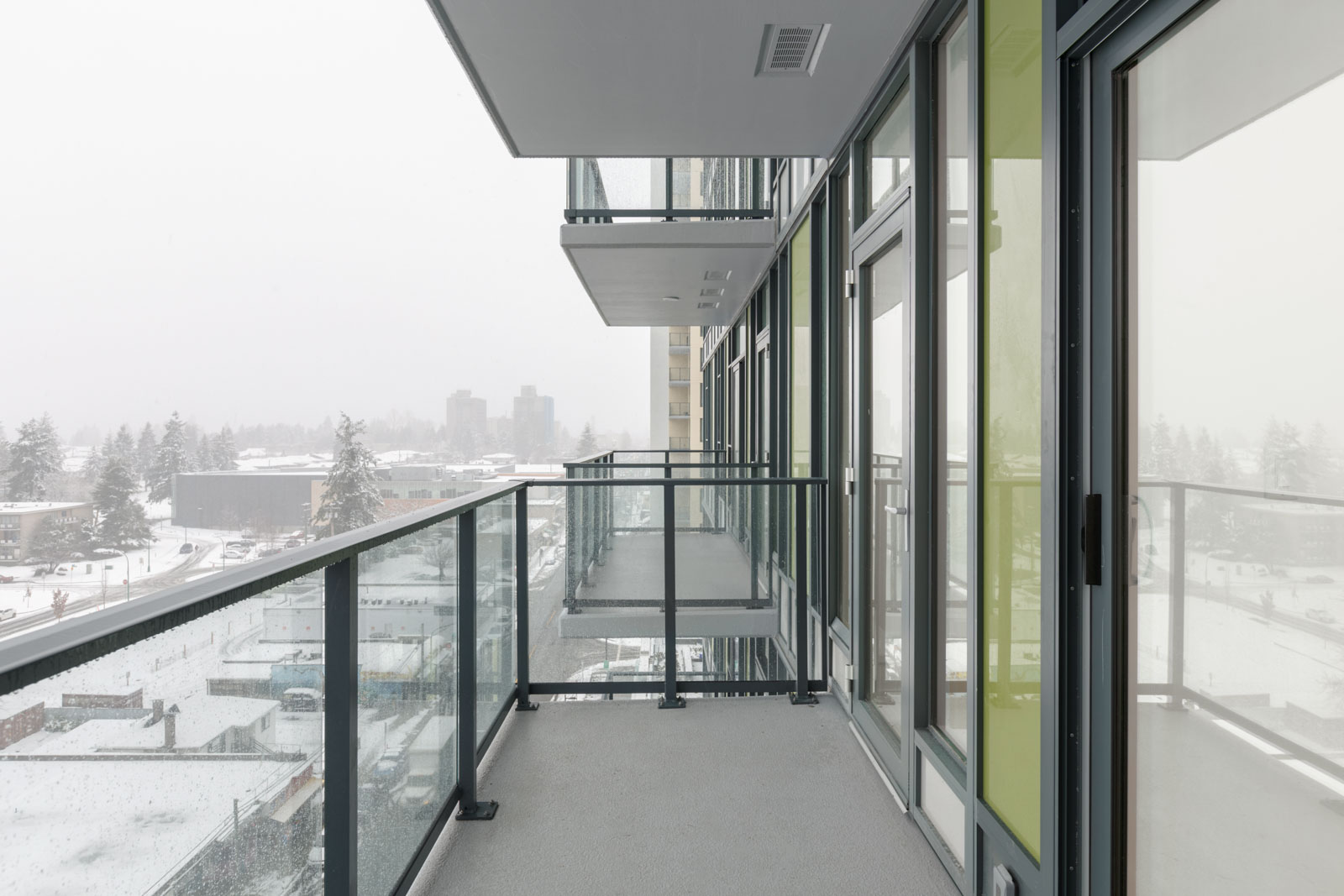 balcony with railing on left and windows to condo on right in empty brand new condo managed by birds nest properties at kings crossing in burnaby