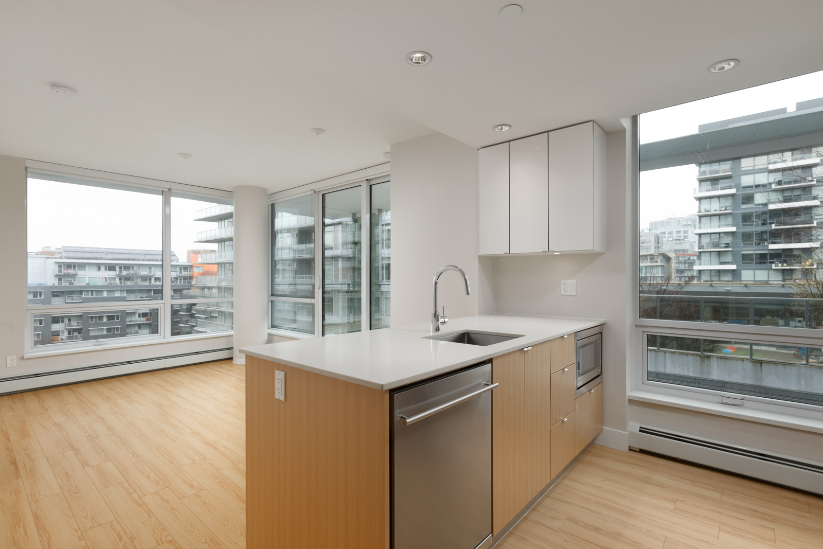 kitchen island with stainless steel dishwasher of rental condo at tower green in false creek olympic village vancouver managed by birds nest properties