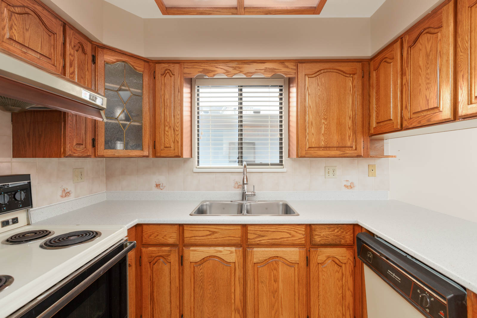 Open kitchen with full range of applianceswith kitchen outlets and window above the sink providing natural sunlight in a rental home in East Vancouver provided by Birds Nest Properties