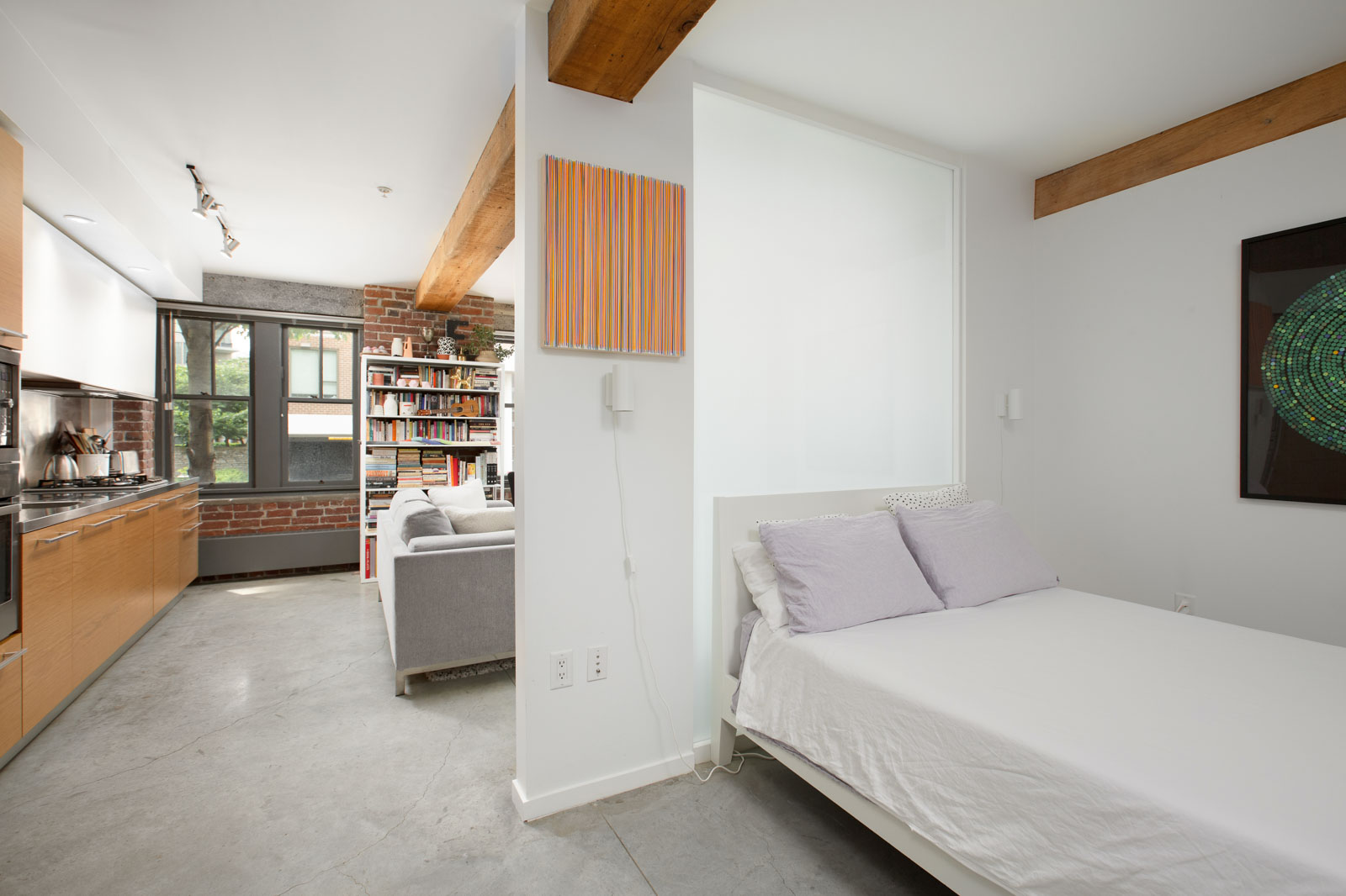 open-concept bedroom with easy access from the living area to the bedroom with large pillars marking the entrance in a rental condo provided by Birds Nest Properties in Vancouver