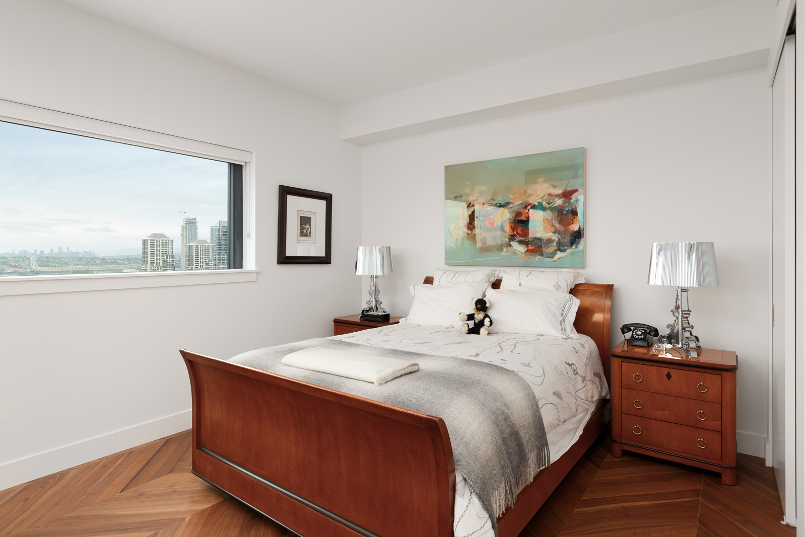 Second bedroom with hardwood flooring and closet storage in a rental condo in Burnaby offered by Birds Nest Properties.