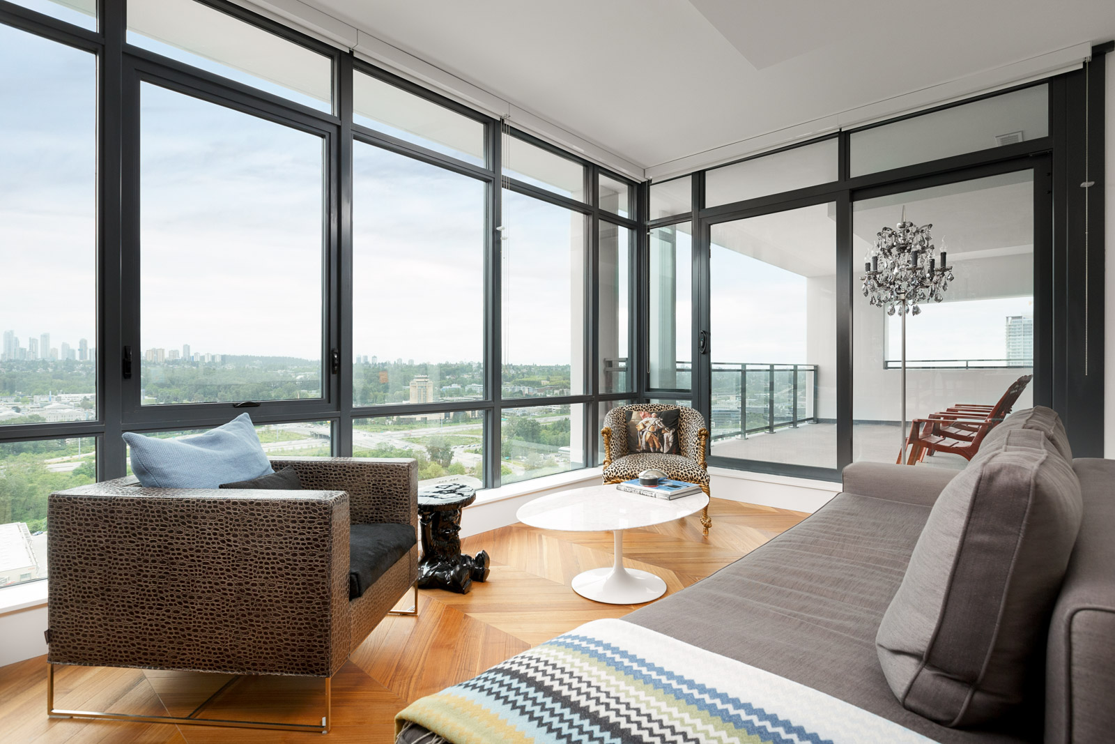 Large floor-to-ceiling windows providing natural sunlight with entertainment space and access to the balcony in a rental condo in Burnaby offered by Birds Nest Properties.
