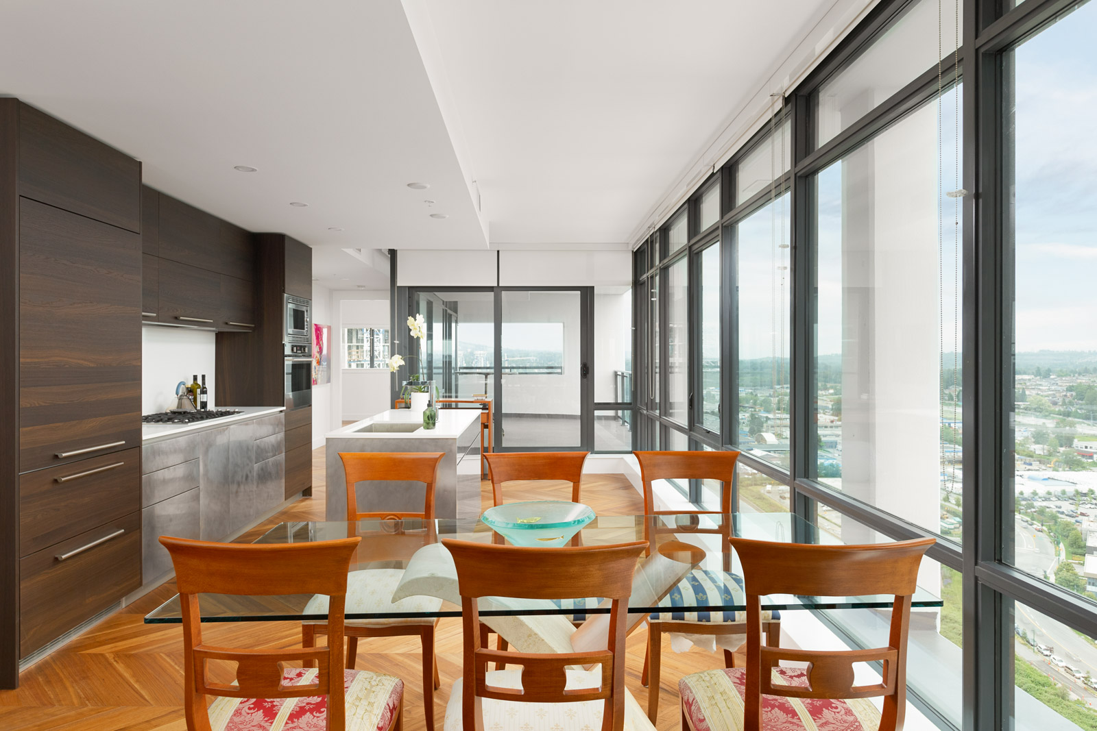 Spacious kitchen and dining area, with floor-to-ceiling windows providing natural sunlight into the unit in a rental condo in Burnaby offered by Birds Nest Properties.