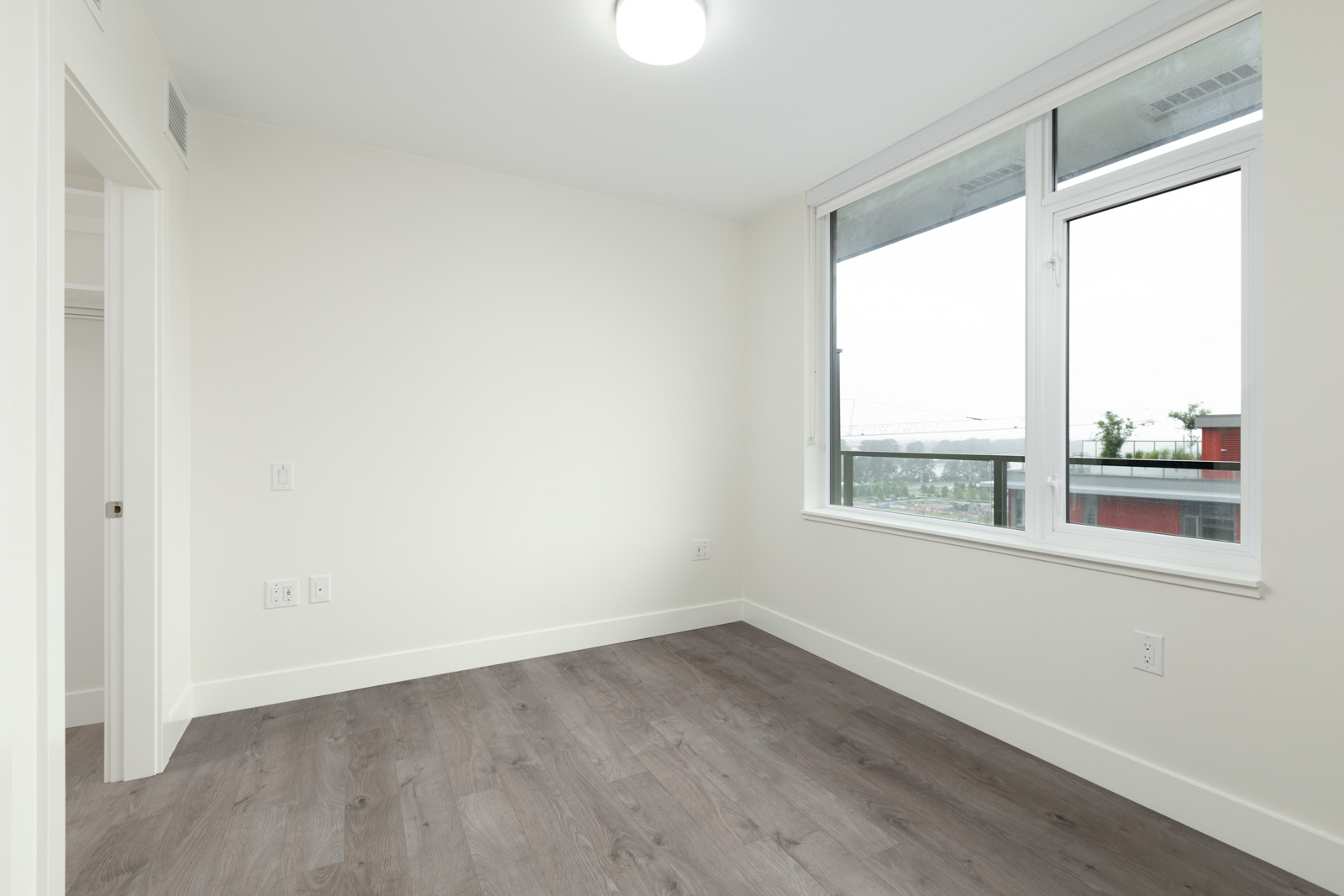 bedroom with white walls and hardwood floors in rental condo in the Downtown neighbourhood of Vancouver