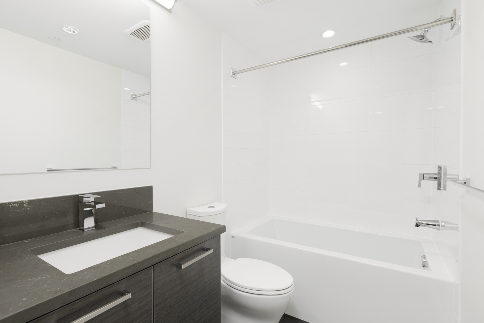 bathroom with white tile, tub, and huge mirror