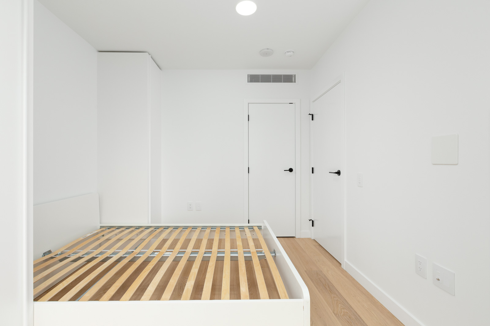 murphy bed on left and closed door on right of bedroom in rental condo in coal harbour neighbourhood in downtown vancouver