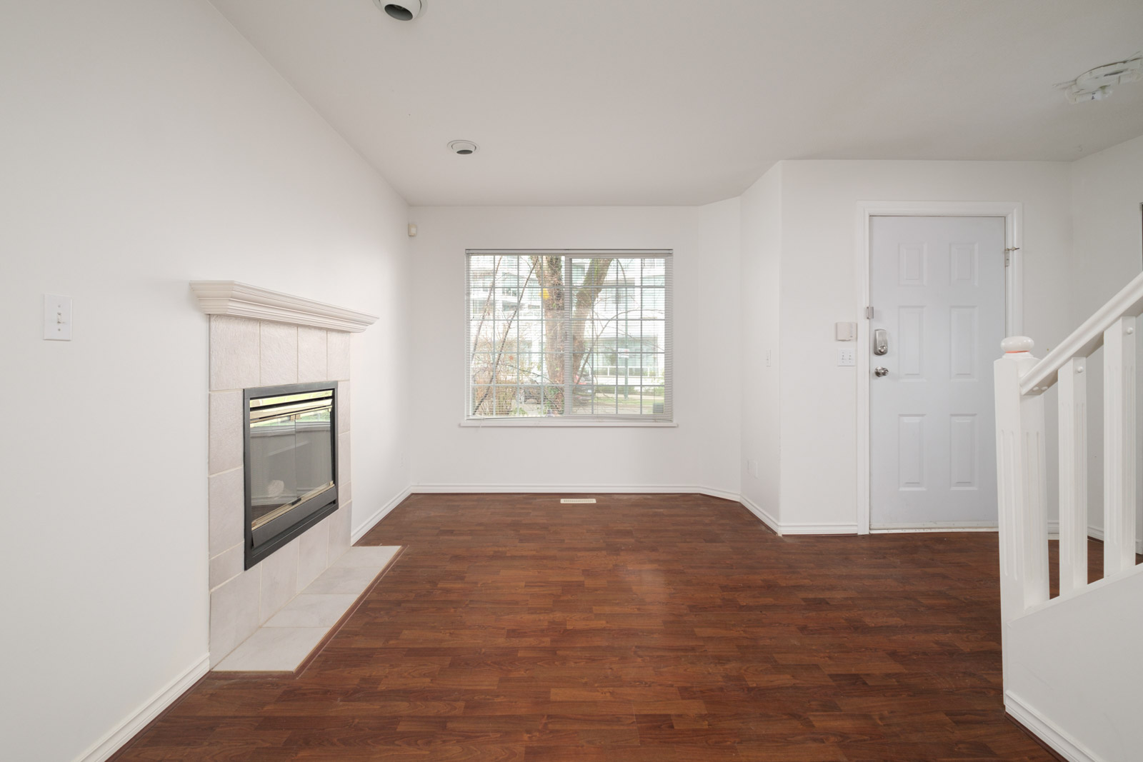 living room with fireplace on left and windows in background in rental house in east vancouver