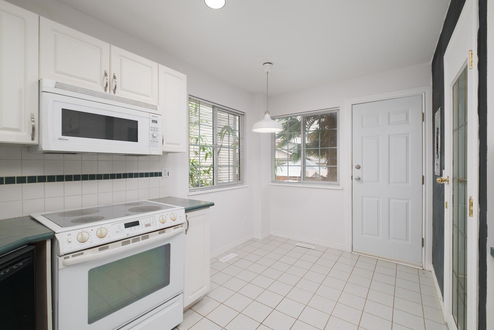 kitchen with over the top white microwave and white oven range on the left in east vancouver rental house