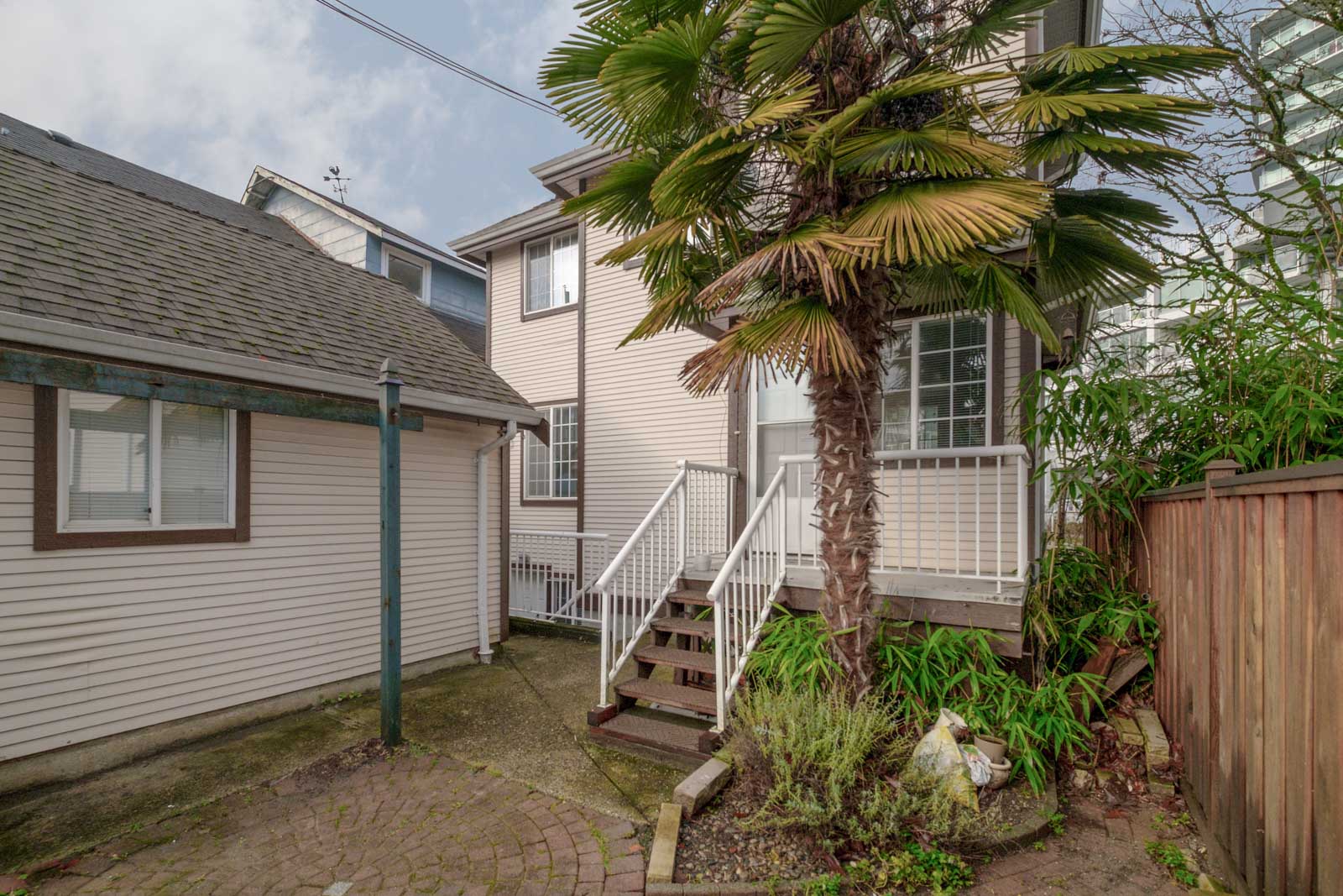 back exterier view of rental house in east vancouver with garage stairs and tree