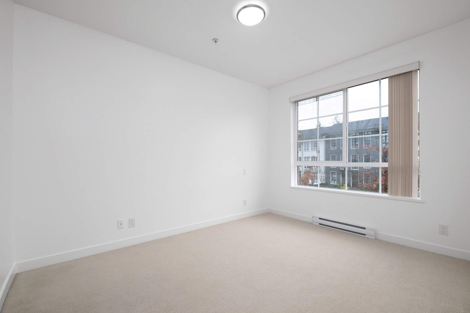 bedroom with white walls and window in rental condo in the Lougheed Town Centre neighbourhood of Coquitlam