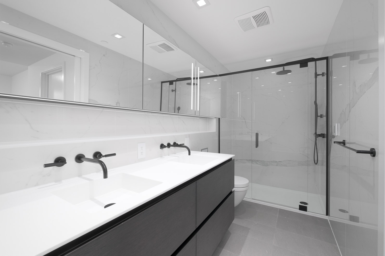 bathroom with white countertops and tiling and clear shower door in rental condo at cardero in downtown vancouver bc