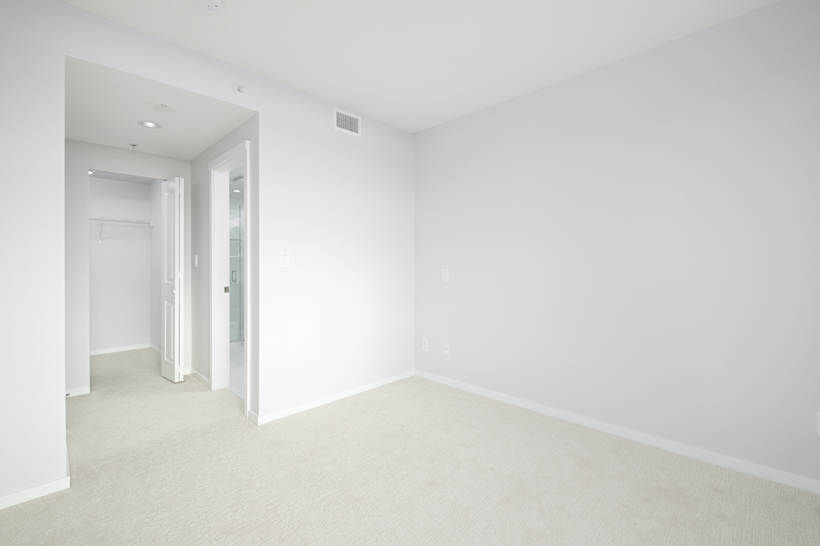 bedroom with white walls and hardwood floors in rental condo in the Metrotown neighbourhood of Burnaby