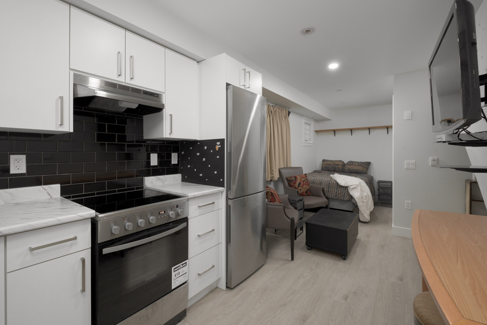 kitchen with laminate flooring with steel fridge in norquay east vancouver