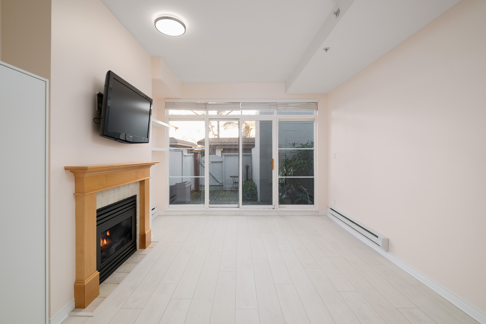 fireplace on right and windows to back patio in kitsilano rental townhome managed by birds nest properties