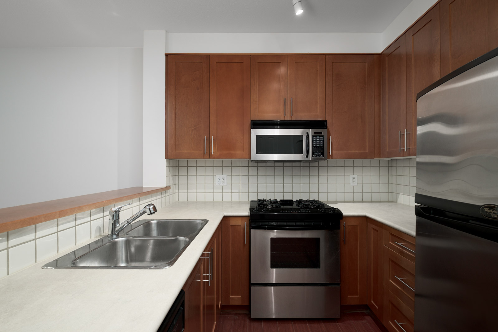 kitchen with dark wood cabinets in garden level apartment in alexandra house in shaughnessy of vancouver westside managed by birds nest properties