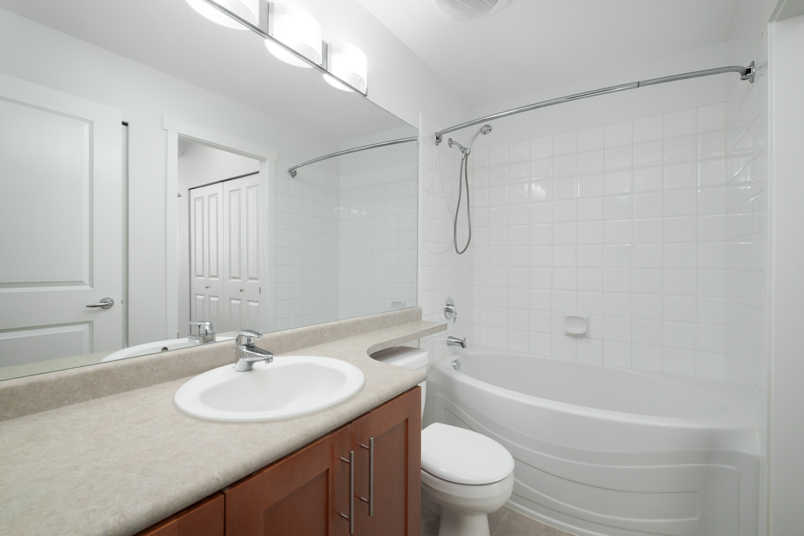 bathroom with vanity and mirror on left and bathtub on right in garden level apartment in alexandra house in shaughnessy of vancouver westside